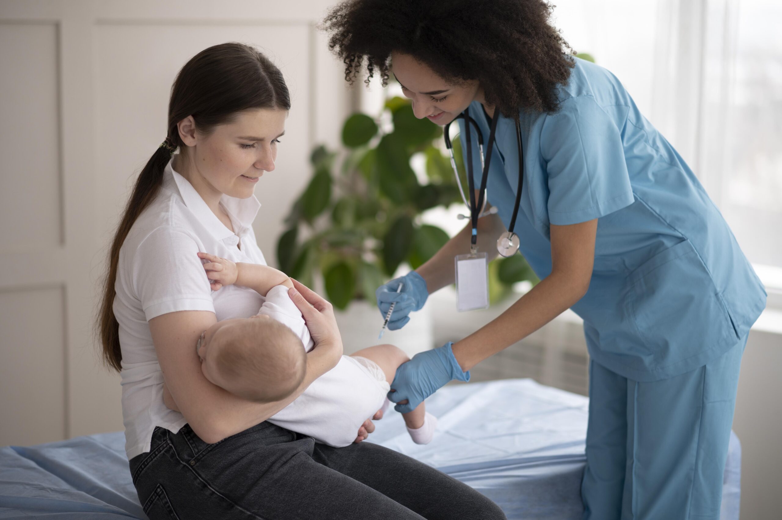 Nurse administering a vaccine to an infant while the mother breastfeeds – IBCLC